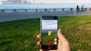 View of a hand holding a phone featuring Pokemon Go