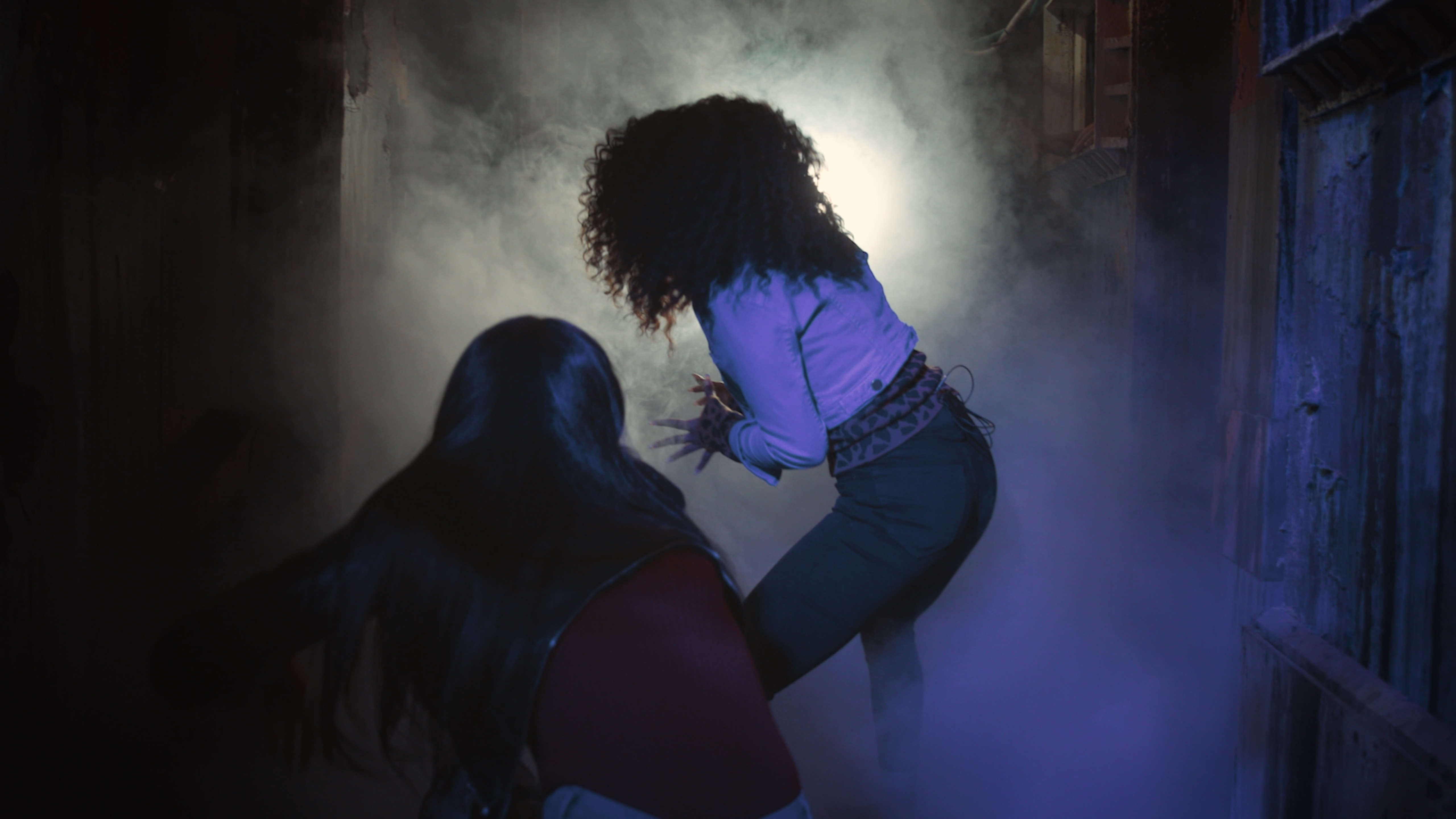 Two women in a hallway of a haunted house with fog around them