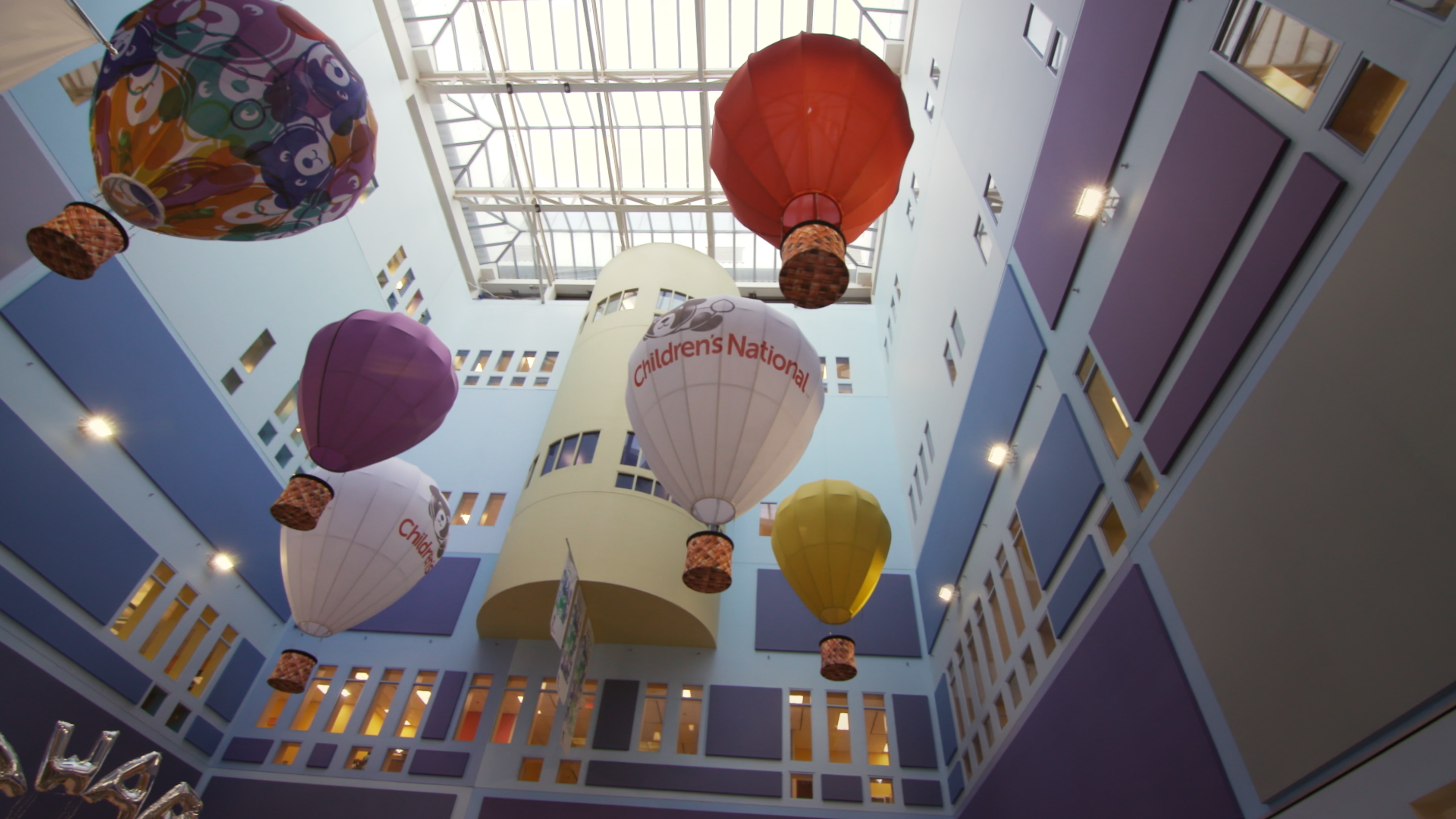Atrium of Childrens National Hospital looking upward at skylight and miniature hot air balloon models