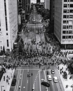 Black and white photo of group of protestors in the middle of a city street intersection