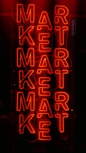Red neon sign with the word market in capital letters repeated three times