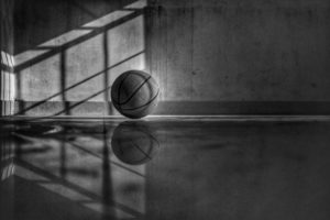 Black and white photo of basketball sitting on court